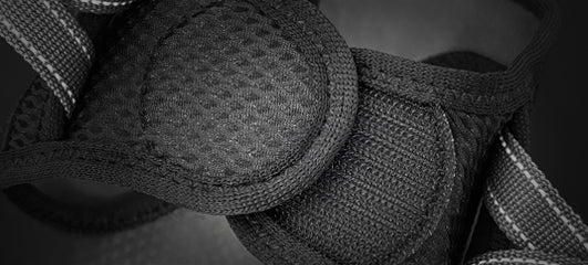 Close-up of a padded black strap on an EzyDog harness, showing the textured material and stitching.