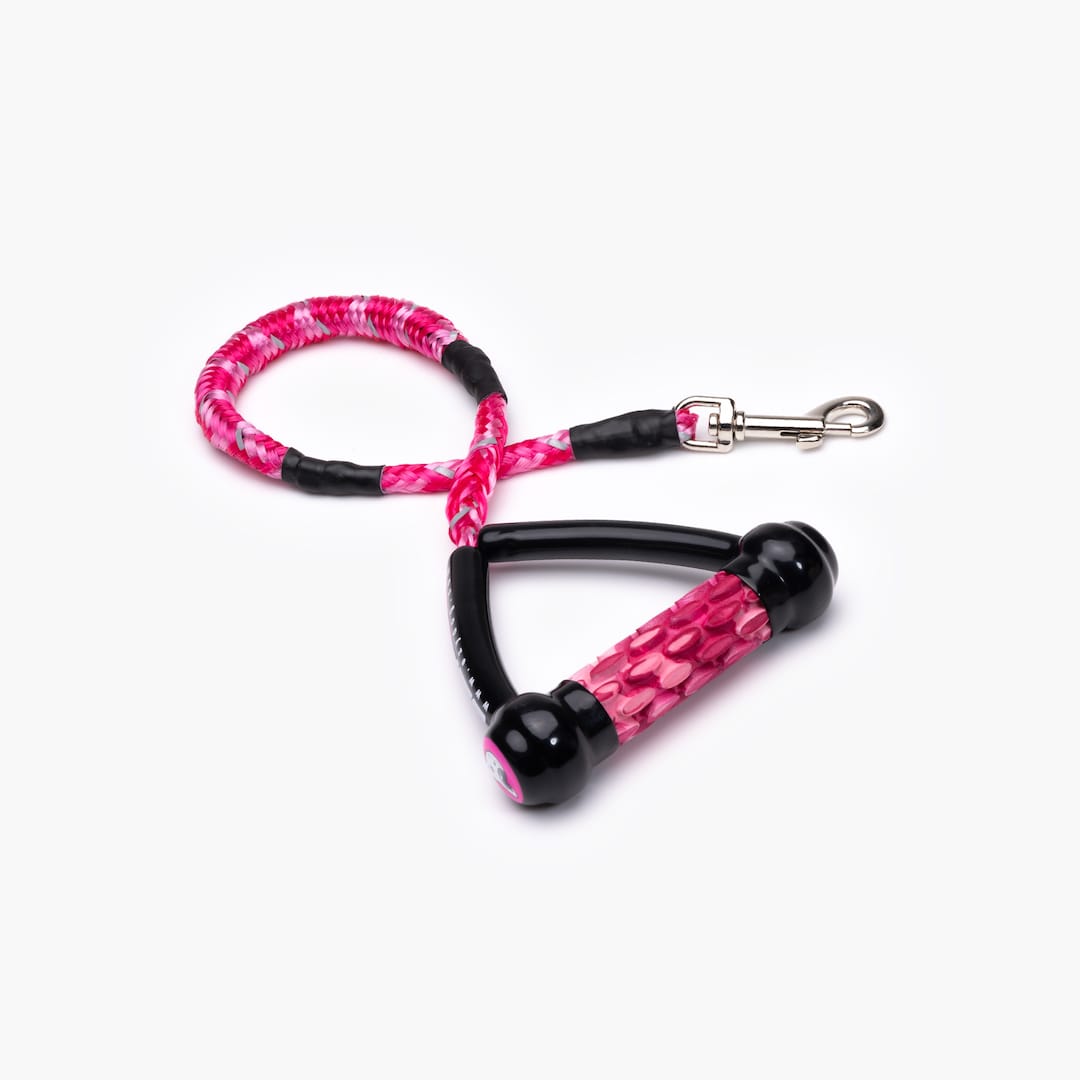 A pink shock-absorbing dog leash with a handle and metal clasp.