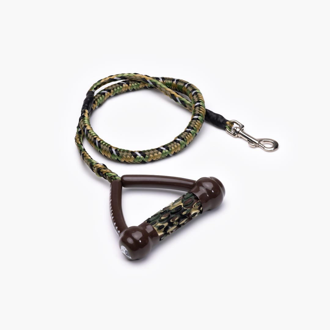 A black and green shock-absorbing dog leash with a handle and metal clasp.