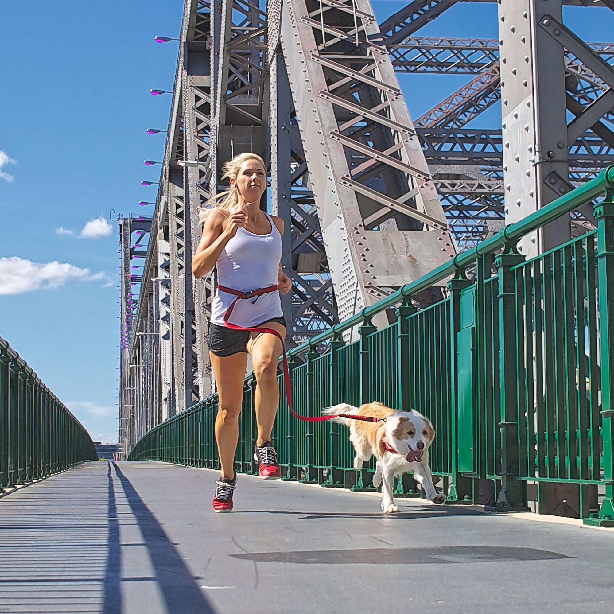 Woman running with a dog on a bridge