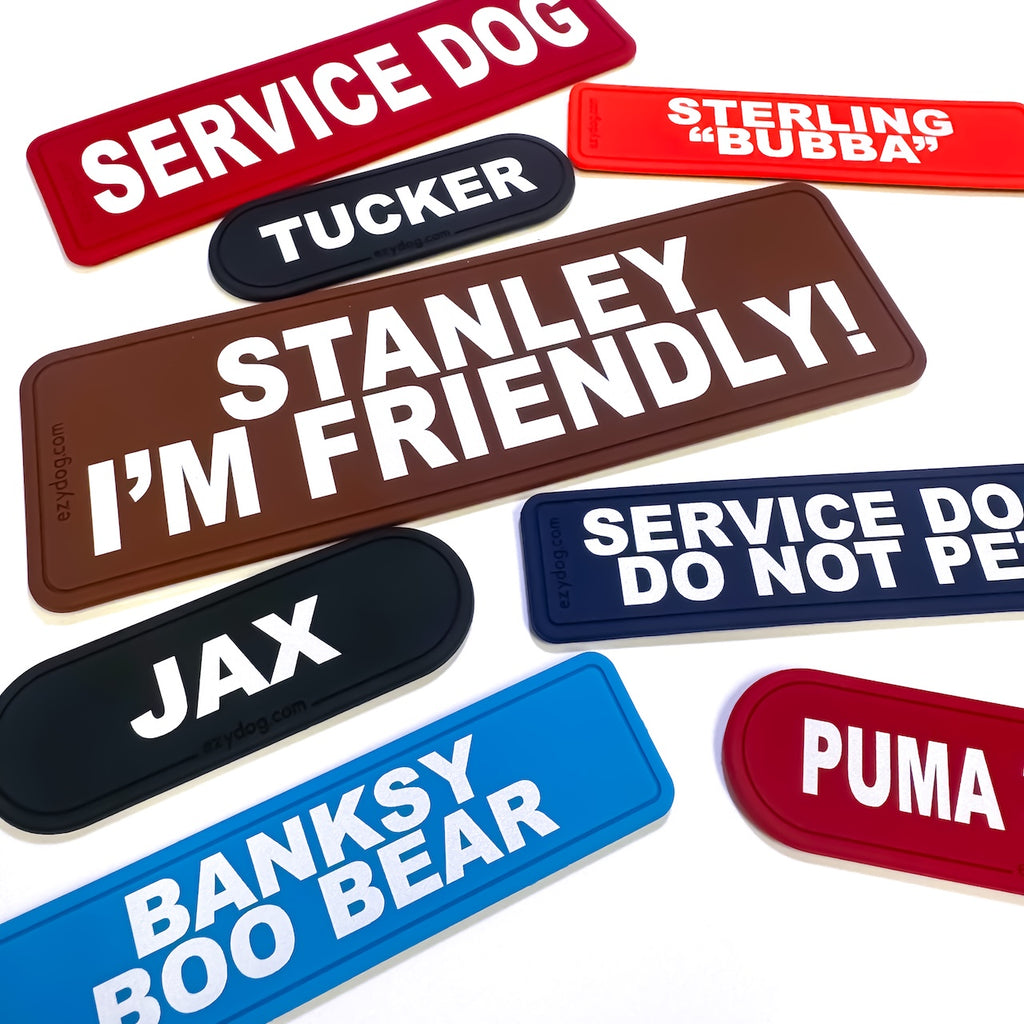 Collection of personalized dog name tags in various colors and text.