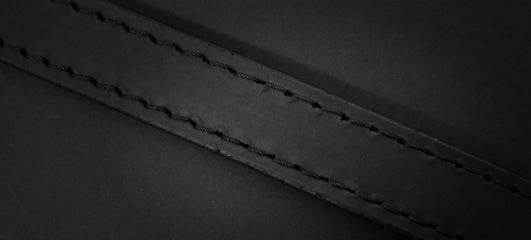 Close-up of a black leather strap with detailed stitching, showcasing its quality and durability.