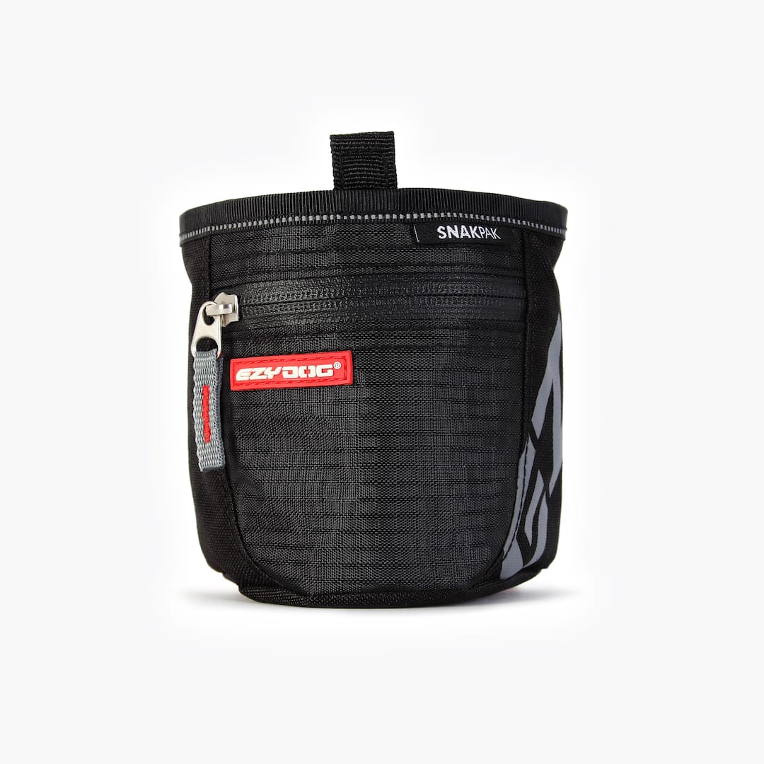 A black SnakPak dog treat bag with magnetic closures and adjustable straps.