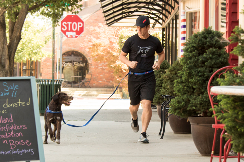 Man running with dog in town